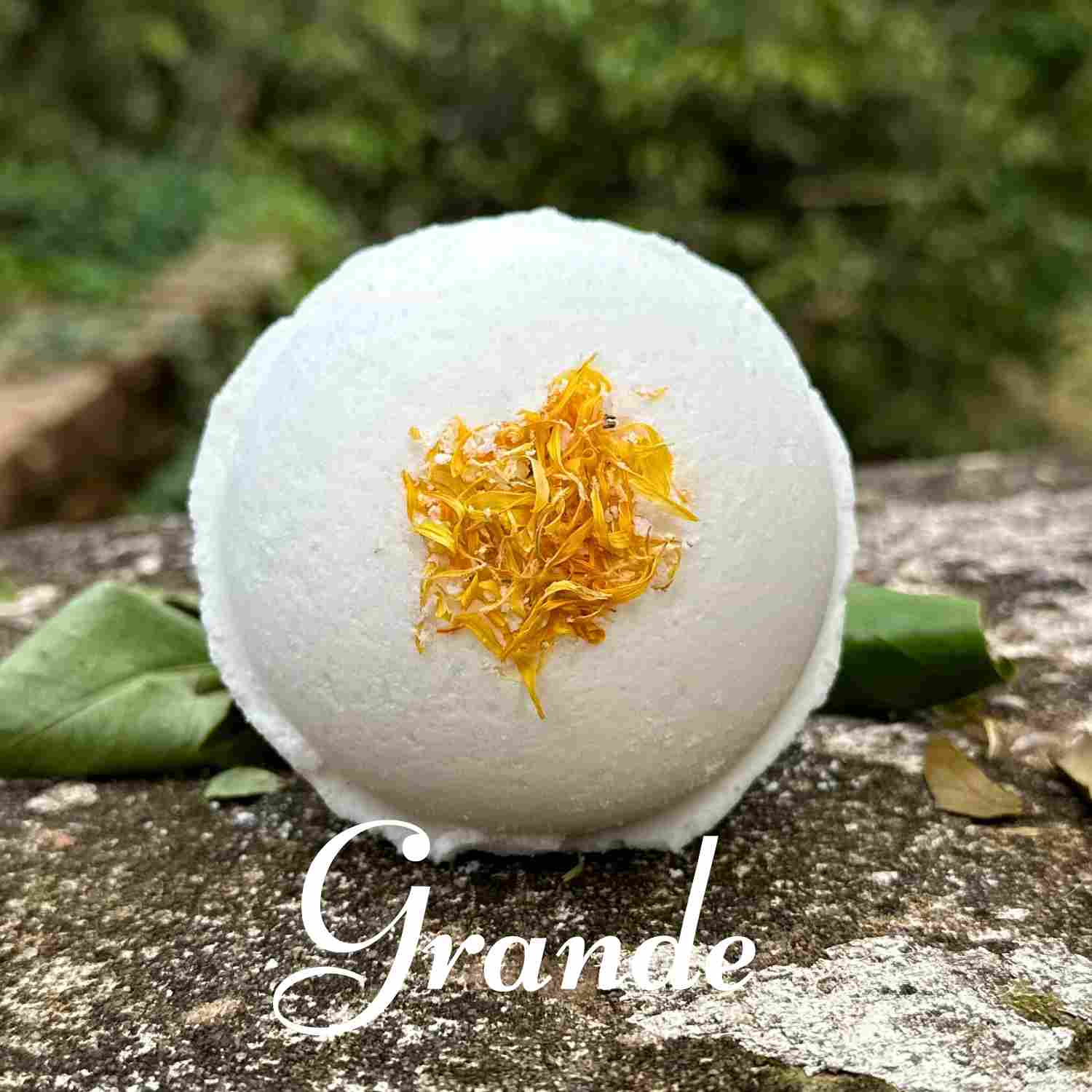 Single Grande size Flora Bath Bomb on stone bench with beautiful nature backdrop