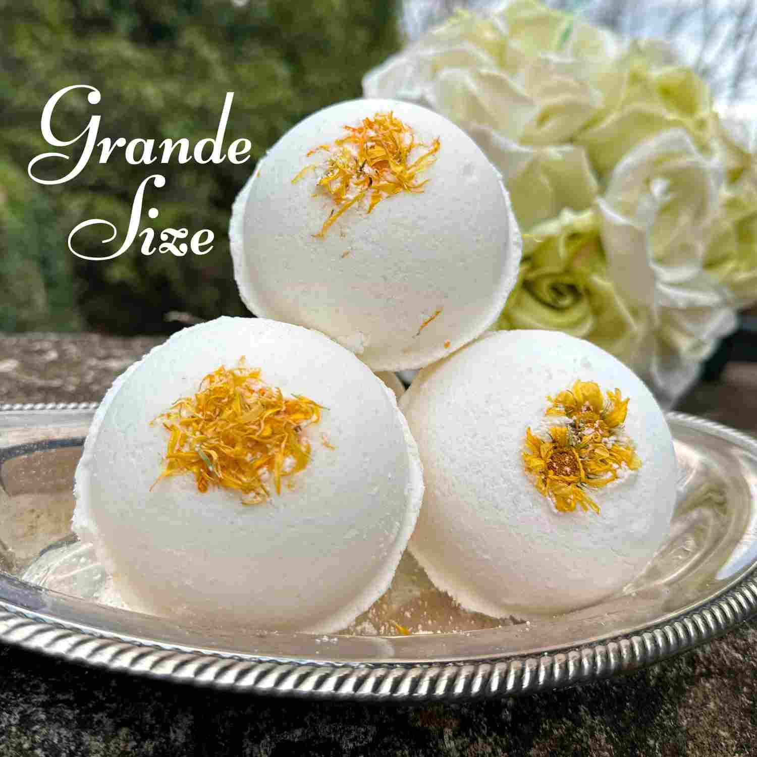 Grande size of Flora Luxuria Bath Bombs, Set of 3 on a silver tray, sprinkled with orange flower petals