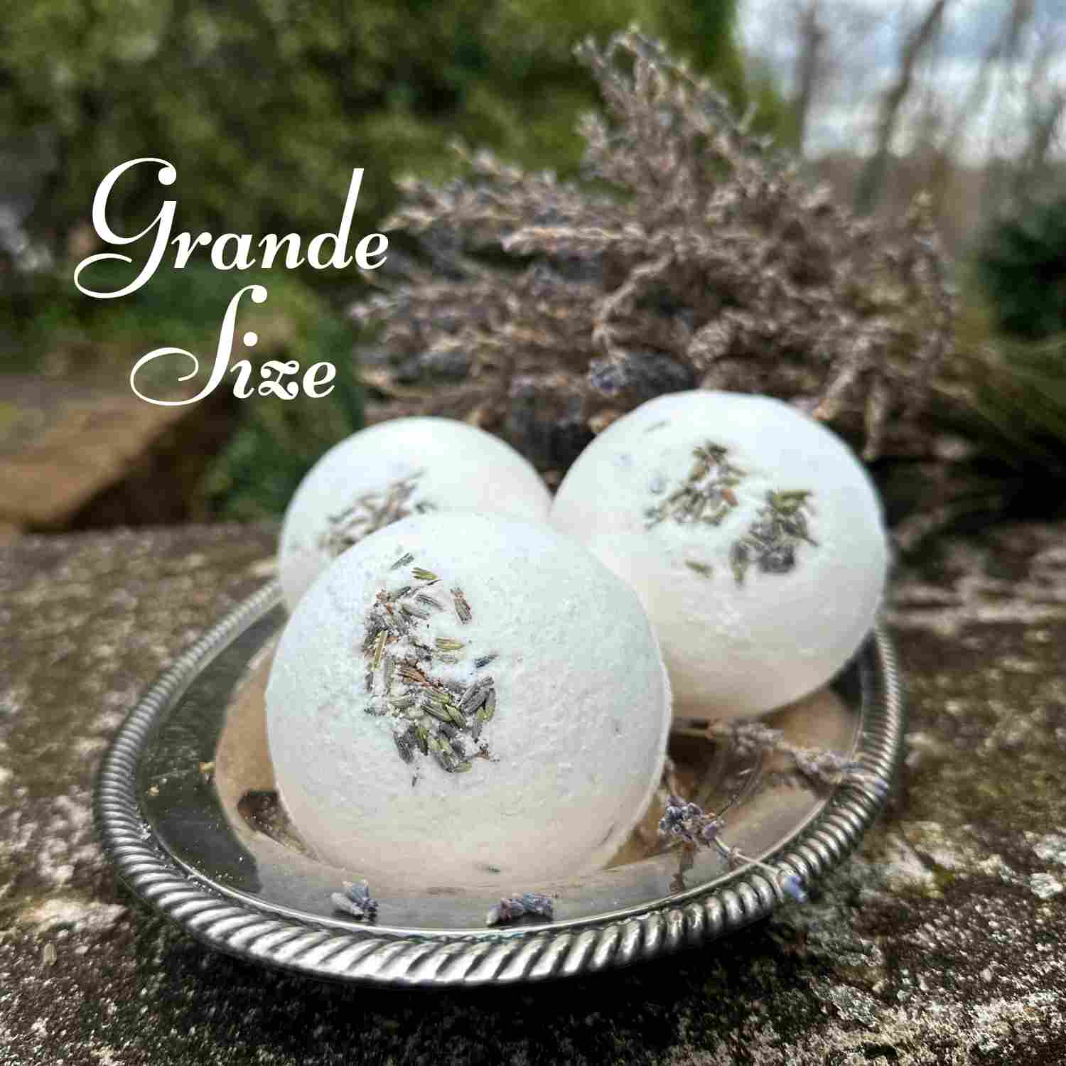 The Grande lavender Bath Bombs on a silver tray with spray of dried lavender in background