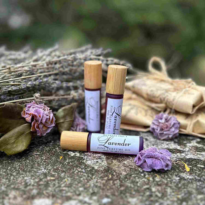 Lavender 10ml Perfume Oil Trio on stone bench with dried lavender and camellias