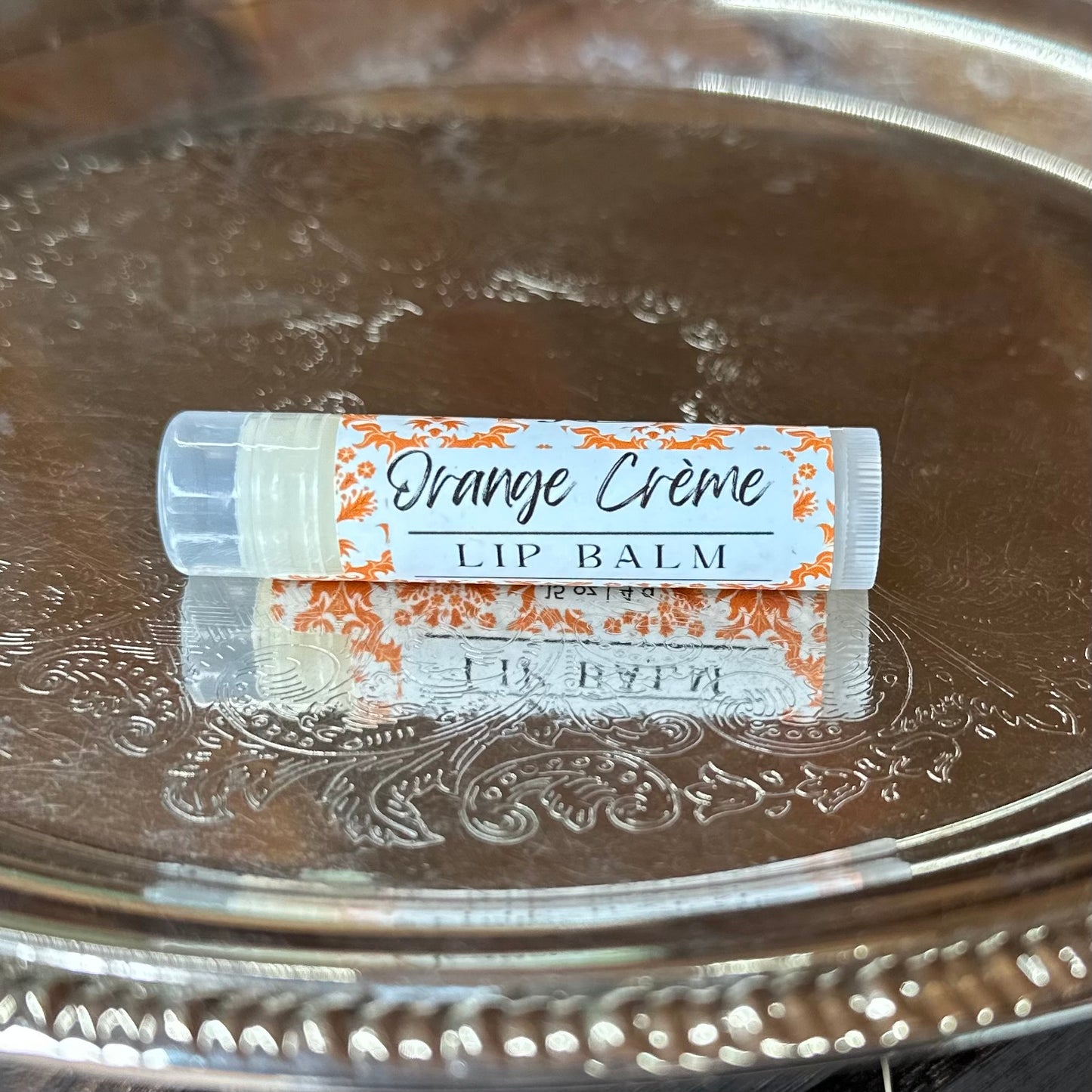 Orange cream lip balm on silver tray